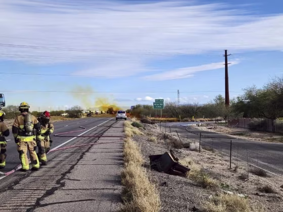 Emergency personnel work at the scene of an accident involving a commercial tanker truck that caused a hazardous material to leak onto Interstate 10