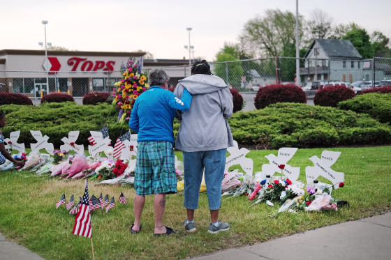 People gather at a memorial for the shooting victims outside of Tops market in Buffalo, N.Y.
