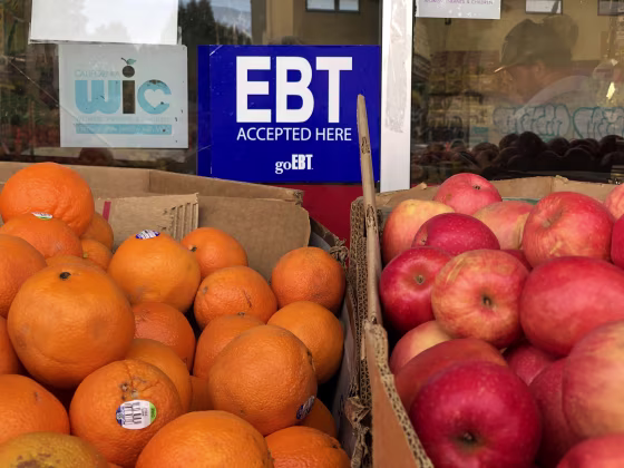 EBT sign over oranges and apples for sale.