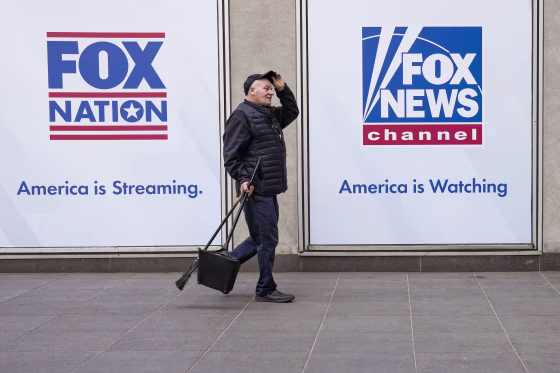 A man walks past the News Corp. Building and Fox News Headquarters on April 19, 2023, in New York.