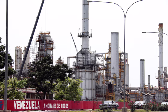 Cars drive pass in fornt of a oil refinery in the Venezuelan city of Moron on April 30, 2009. The petroleum sector dominates Venezuela's mixed economy, around 80% of exports and Venezuela has the least expensive petrol in the world because of its high government subsidies.