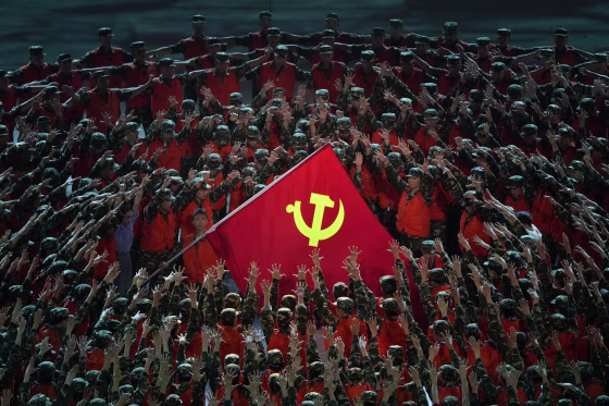 Performers gather around a Communist Party flag during a gala show ahead of the 100th anniversary of the founding of the Chinese Communist Party in Beijing on June 28, 2021.
