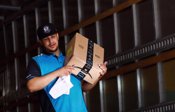 An Amazon worker unloads boxes from a truck in New York City,