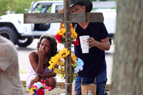 A woman pays her respects to shooting victims on Aug. 28, 2023 near the site of the Dollar General store shooting In Jacksonville, Fla.