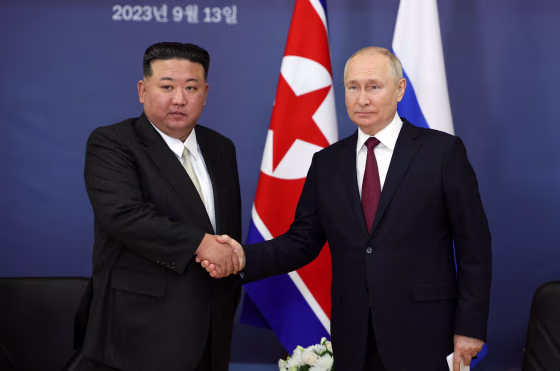 Kim Jong Un, left, and Vladimir Putin shake hands