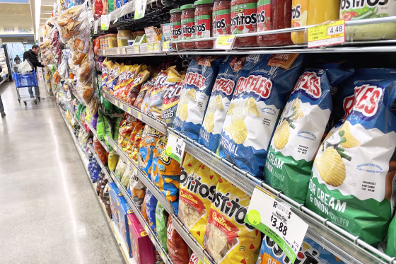 Sale priced potato chips are displayed at a grocery store on February 10, 2023 in San Anselmo, California. Super Bowl fans are seeing lower prices of their favorite game day foods like chicken wings and guacamole. Avocados are an estimated 20 percent cheaper than last year and the price of chicken wings is down nearly one dollar per pound.