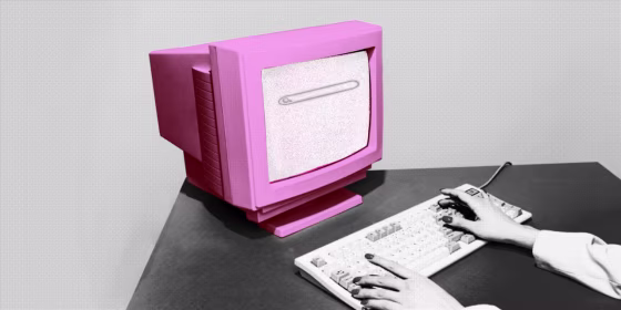 Pink vintage computer on a dark gray desk and gray background