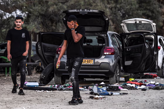 Image: A man walks between damaged cars on Oct. 12, 2023 near Kibbutz Beeri
