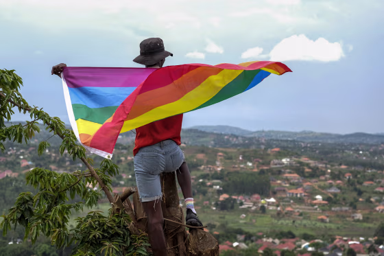 A gay man poses with a Pride flag in Uganda on March 25, 2023. 