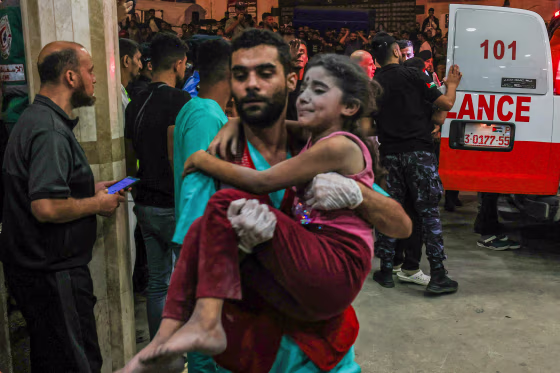 A Palestinian child injured in an Israeli airstrike is carried inside the Nasser hospital in Khan Yunis, Gaza, on Oct. 17, 2023.