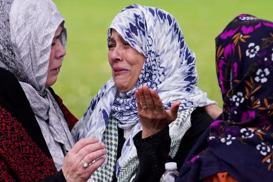 Muslim community members cry at the grave of Wadea Al Fayoume in LaGrange, Ill., on Oct. 16, 2023. 