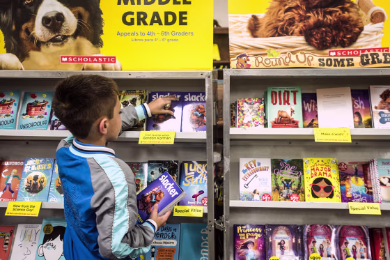 A boy picks out a book at a book fair