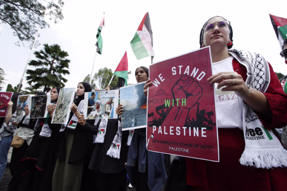 Protesters hold signs during the solidarity rally with