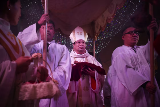 The head of the Catholic church in China began a trip to Hong Kong on Tuesday at the invitation of the city’s pope-appointed Roman Catholic cardinal, marking the first official visit by a Beijing bishop in history.