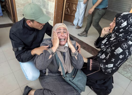 People mourn as they collect the bodies of Palestinians killed in Israeli raids, in Khan Yunis, Gaza