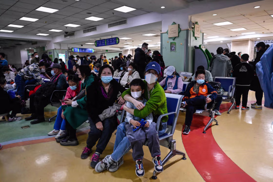 Children and their parents wait at an outpatient area at a children hospital in Beijing on November 23, 2023. A surge in respiratory illnesses across China that has drawn the attention of the World Health Organization is caused by the flu and other known pathogens and not by a novel virus, the country’s health ministry said Sunday.