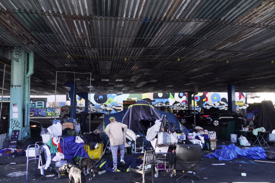 A woman gathers possessions to take before a homeless encampment was cleaned up in San Francisco, CA.