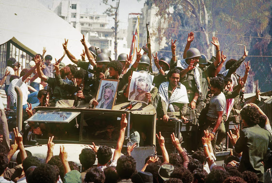 Palestinian fighters hold portraits of Yasser Arafat, chairman of the the Palestine Liberation Organization, on Aug. 22, 1982, as they leave Israeli-occupied Beirut for Tunis.