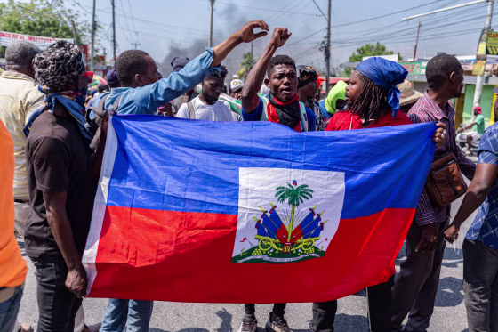 People carry a Haitian flag during a demonstration