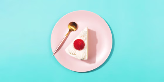 strawberry cheesecake on the pink plate on blue background. Flat-lay, top view.