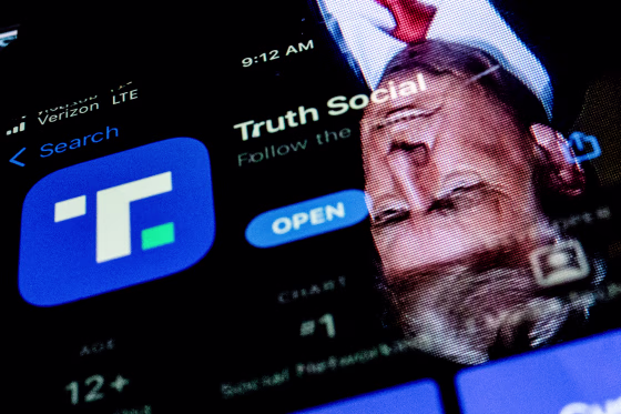 This photo illustration shows an image of former President Donald Trump reflected on a phone screen that is displaying the Truth Social app