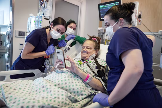 Lisa Pisano looks at her phone with hospital staff