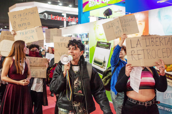 A demonstrator speaks through a megaphone while other protesters hold signs