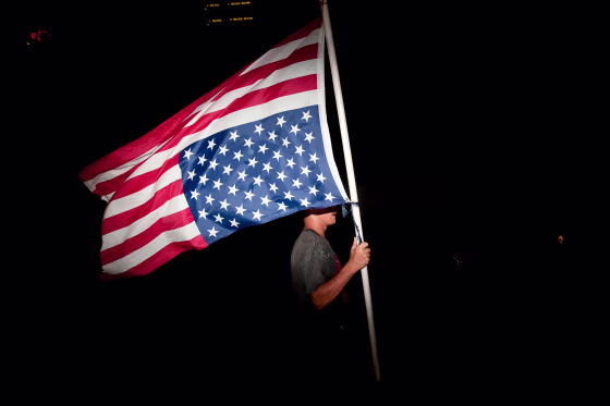 A protester with an upside-down American flag 