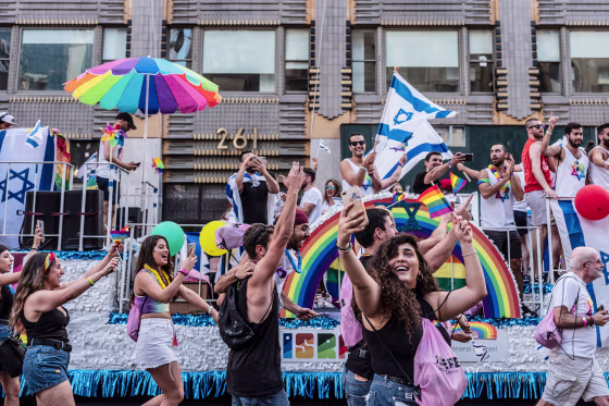 People take pictures in front of the Israel float