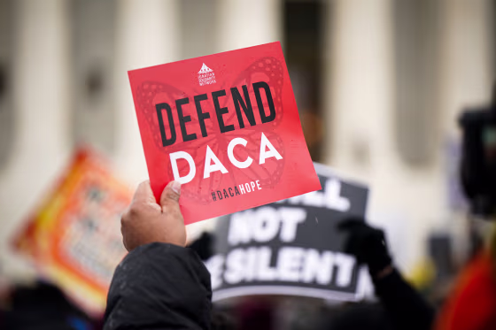 Immigration rights activists with a sign that reads 'DEFEND DACA.'