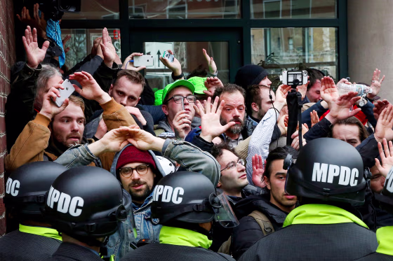 Protesters raise their hands.