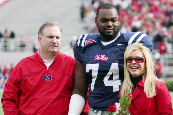 Michael Oher and Sean and Leigh Anne Tuohy on the field