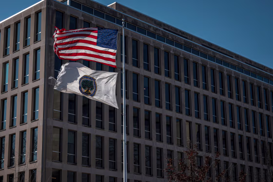 A U.S. flag and an Education Department flag fly.