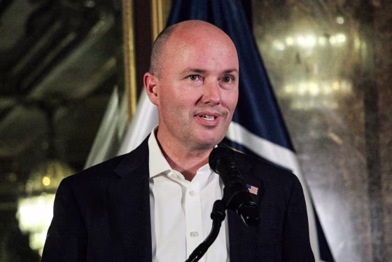 Spencer Cox speaks into a microphone