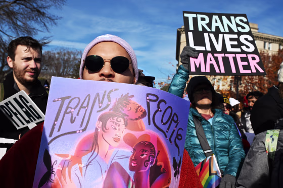 A protester holds a sign that reads, "Trans Lives Matter."