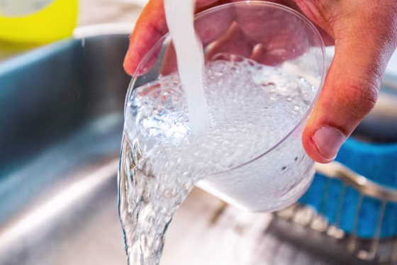 Tap water is poured into a cup from a faucet