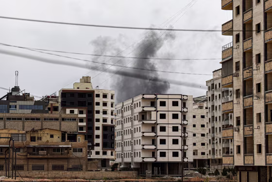 Smoke billows from behind a building