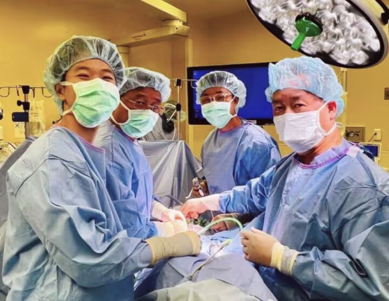 Huy Nguyen, second left, escaped Vietnam at age 12, and became a surgeon. Front right is his brother, Nang Nguyen, also a practicing surgeon. Nguyen’s two sons are left – Eric Nguyen, a family medicine resident, and second right, Brandon Nguyen, a surgical resident.