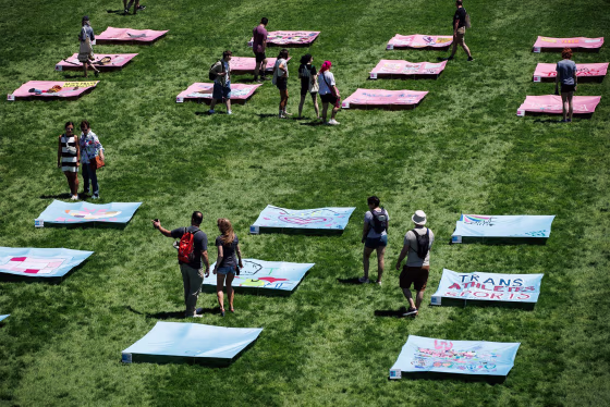 People view sections of the "Freedom to Be" quilt laid out on the grass on the National Mall at the launch of World Pride on May 17, 2025.