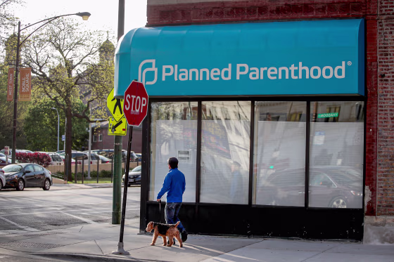 A person passes in front of a closed planned parenthood.