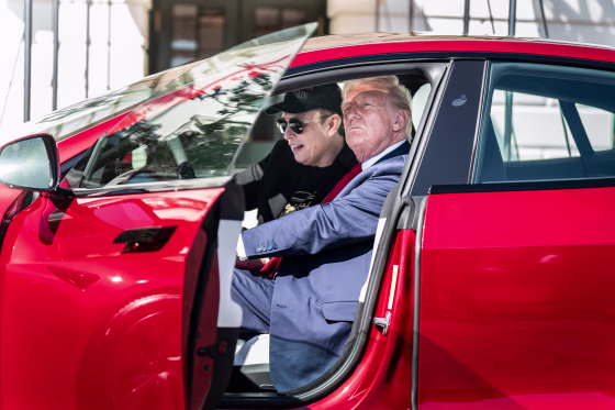 Elon Musk and President Donald Trump inside of a Tesla model S vehicle parked outside of the White House
