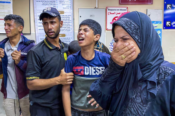 Palestinians react as they await news of a relative who was injured in Israeli strikes.