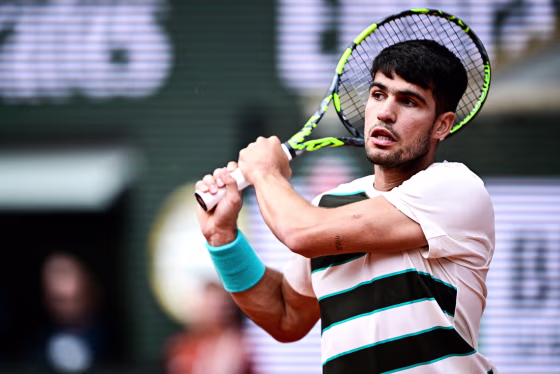 Carlos Alcaraz holds his racket behind his head