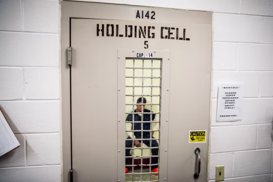 A detainee sits in a holding cell