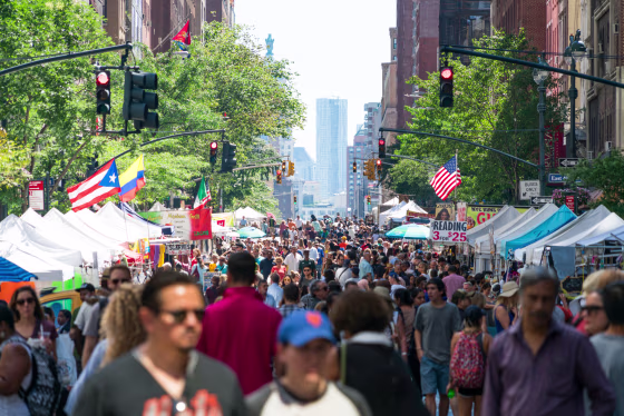 Street Fair was opened on the Lexington Avenue at Midtown Manhattan New York on Jul. 30 2017. Crowd walks down the Lexington Avenue among the many street shops along the tree lined street. Rows of Midtown buildings can be seen behind.