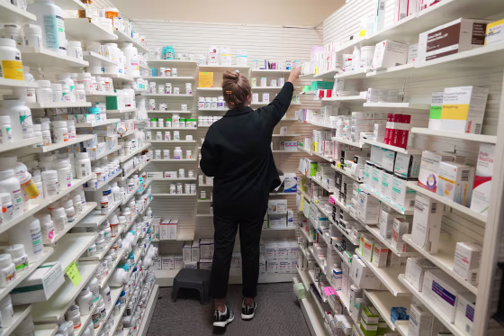 A pharmacy tech looks for a drug on a shelf at a pharmacy in Provo, Utah, on Aug. 7, 2025.