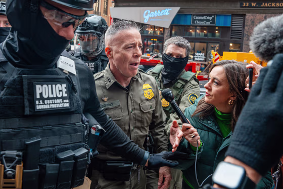 U.S. Border Patrol commander Gregory Bovino pushes through a crowd of media and protesters as he enters the Dirksen Federal Building on Oct. 28, 2025, in Chicago.