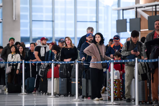 Image: People wait in a security checkpoint line at George Bush Intercontinental Airport