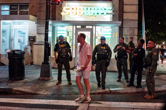 FBI and Border Patrol officers speak with Sean Charles Dunn along the U Street corridor on Aug. 10, 2025 in Washington, D.C.