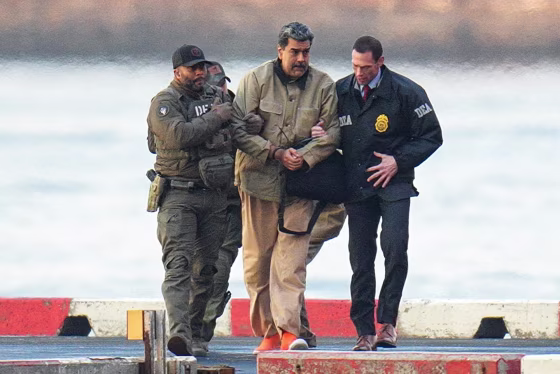 Nicolas Maduro, with zip-tied wrists, is escorted by DEA agents outside